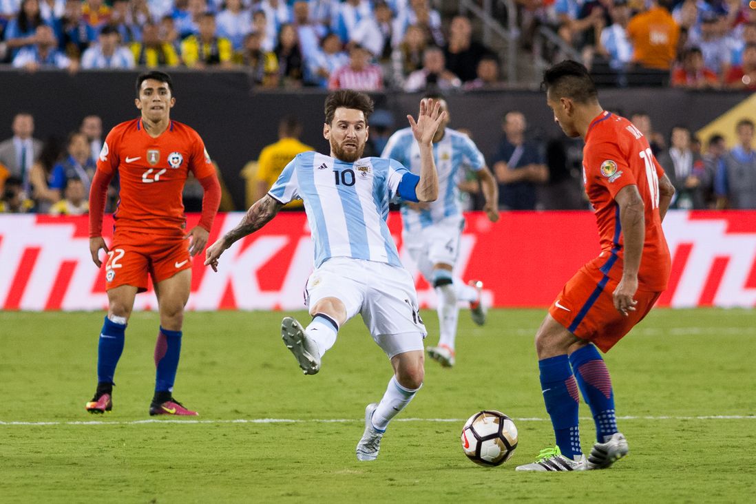 Argentina's Lionel Messi (10) vies with Chile's Gonzalo Jara (right) while Edson Puch (22) looks on.